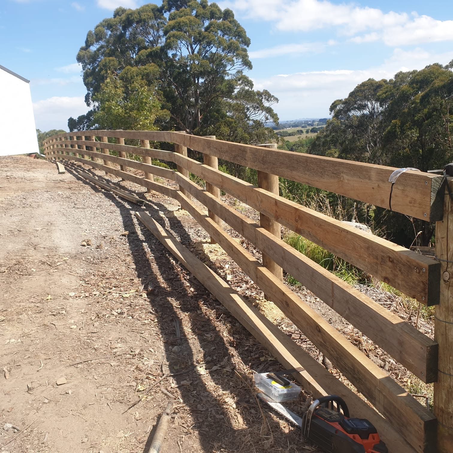 Farm machinery alongside newly built wire fence